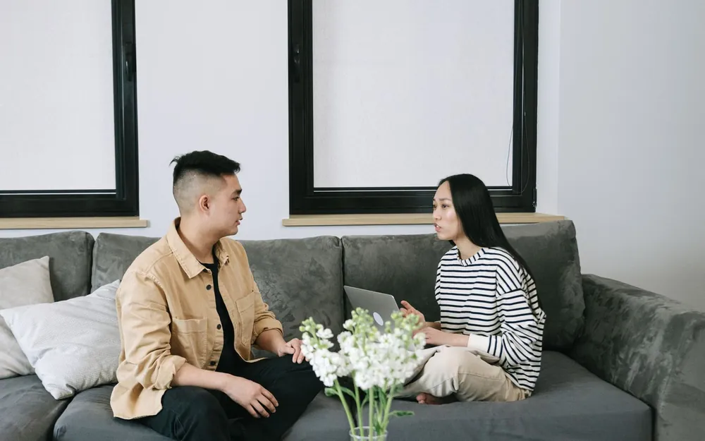 Two adults in a calm conversation on a sofa